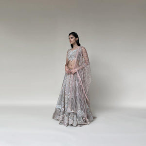 Organza silk lengha with a fine play of geometric and floral motifs with 3D embroidery and bugle bead detailing on the blouse. There is a fine play of Resham, sequin, pearl and katdana detailing. The look has playful young vibes that is perfect for someone who loves new and different vision about design. Abhishek Sharma, Abhishekstudio.