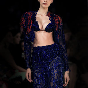 Close-up of blue embellished sheer skirt set with red accents and top - bold power-shoulder fashion statement, top and skirt, blue red outfit