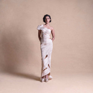 Full-length view of model in asymmetrical cream cutout dress – sculptural wrap detailing, modern resort look