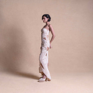 Model in cream sculptural cut-out dress – side profile showcasing asymmetric design