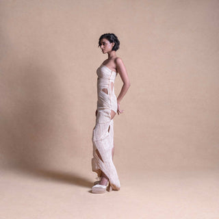 Model in cream sculptural cut-out dress – side profile showcasing asymmetric design