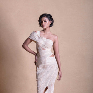 Studio portrait of model in asymmetric cream dress with wrap-style cutouts – contemporary resort fashion