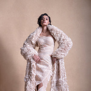 Model in sculptural cream wrap dress and voluminous textured coat – modern high-fashion layering