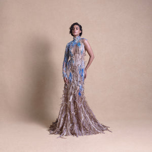 Model in eco-luxury gown inspired by crop fields with blue floral accents on neutral studio backdrop - eco-luxury fashion, reception gown