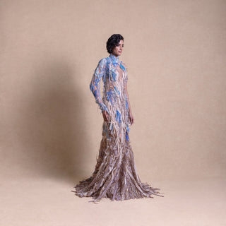 Side view of model in flowing earth-toned gown with blue floral embroidery and textured embellishments - eco-luxury fashion, reception gown, sustainable runway look