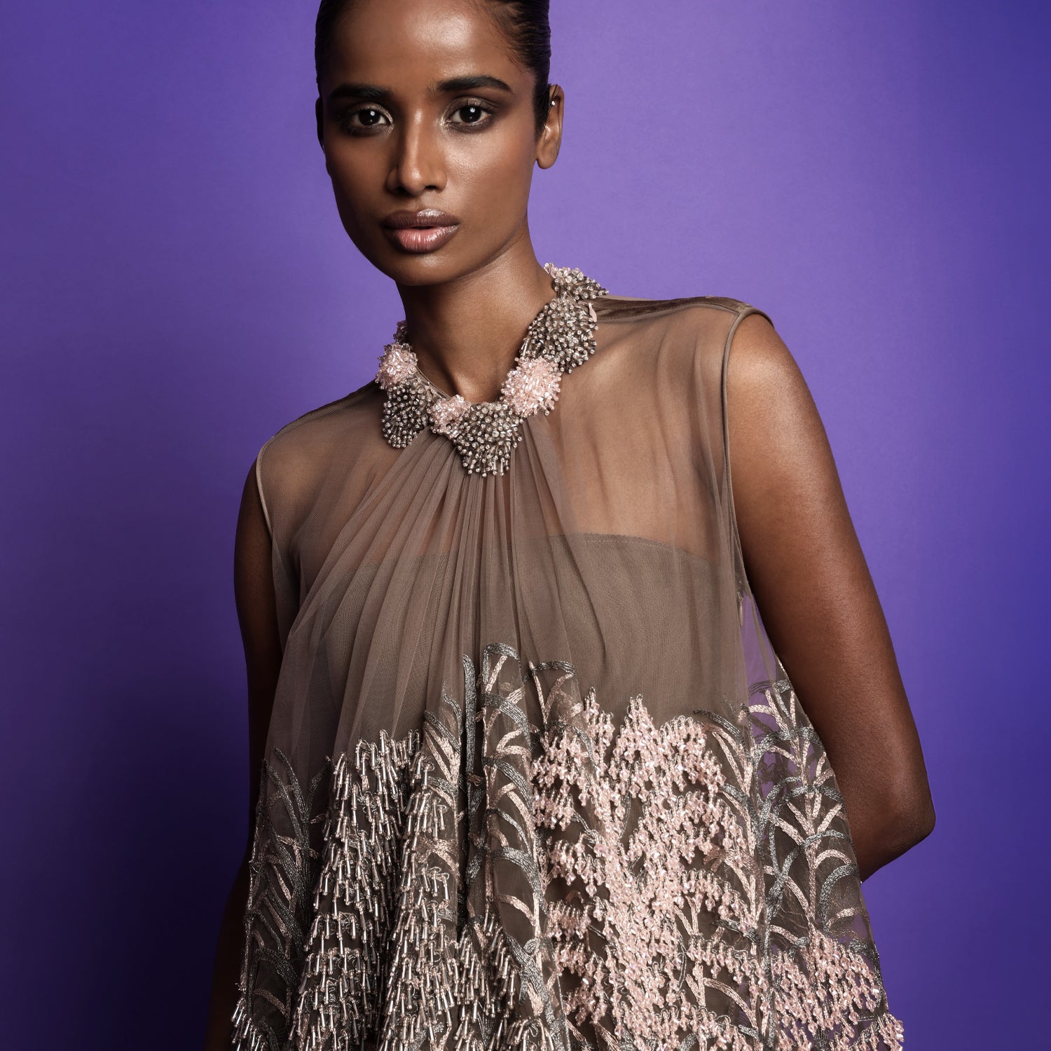 Close-up of anti-fit dress with intricate pink and silver embroidery, paired with a sculptural beaded floral necklace - artistic high fashion outfit, youngester dress