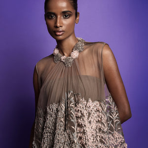 Close-up of anti-fit dress with intricate pink and silver embroidery, paired with a sculptural beaded floral necklace - artistic high fashion outfit, youngester dress