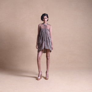 Front view of a model wearing a sleeveless, sheer balloon mini dress with a softly pleated silhouette in neutral tones - artistic high fashion outfit, youngester dress, luxury womenswear