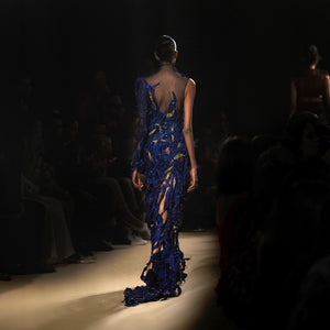 Back view of model wearing an asymmetrical electric blue couture gown with sheer detailing -  asymmetrical dress, sheer couture, red carpet couture gown, cocktail gown