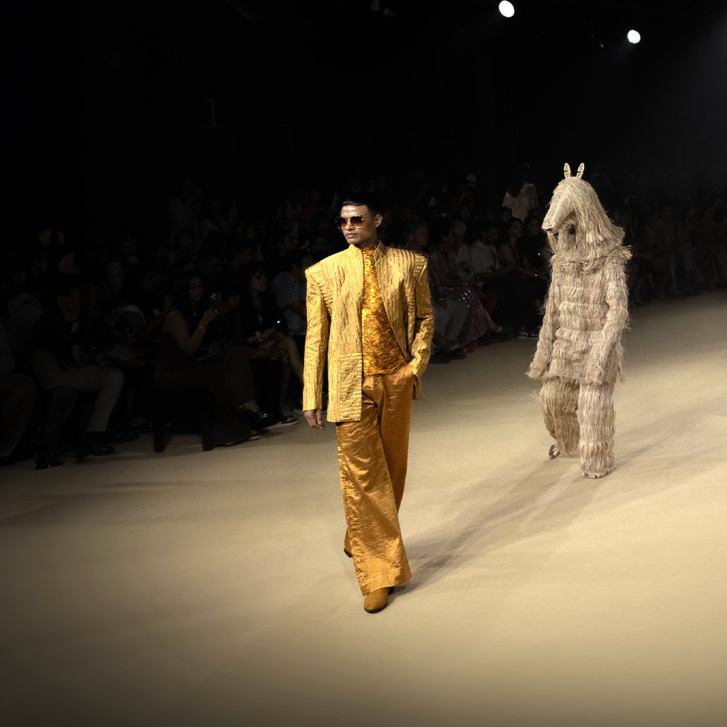 Male model in metallic gold textured Bandhgala tuxedo with embellished shirt and flared trousers walking runway at fashion show - Tuxedo, retro suit, menswear