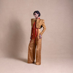 Model in Structured designer jacket with flared pants angular shoulders and cascading red beaded fringe, posing against a neutral beige background - high fashion ensemble, powershoulder jacket, metallic.