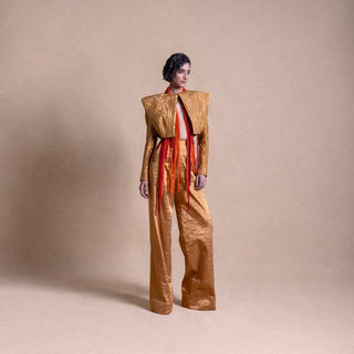 Fashion model wearing a structured Structured designer jacket paired with flared pants long red beaded fringe, standing against a soft beige background - high fashion ensemble, powershoulder jacket, metallic.