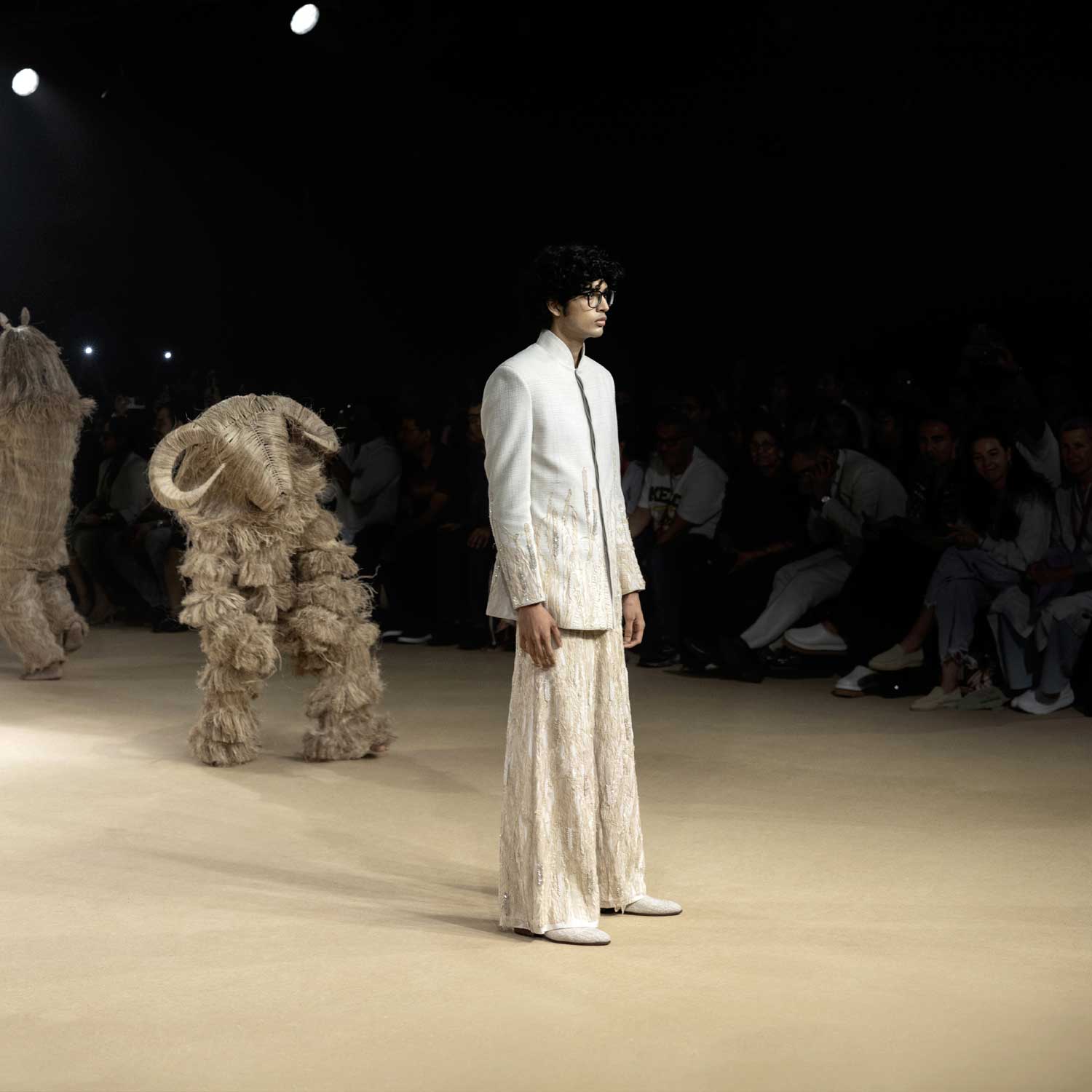 Runway model in bandhgala jacket and textured wide-leg pants – modern artisanal menswear - Designer bandhgala for men, Luxury Indian menswear, Artisanal menswear