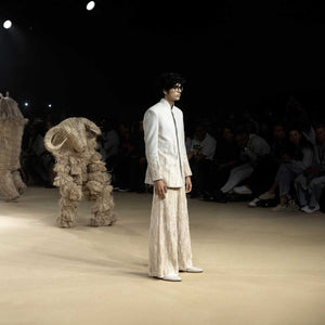 Runway model in bandhgala jacket and textured wide-leg pants – modern artisanal menswear - Designer bandhgala for men, Luxury Indian menswear, Artisanal menswear