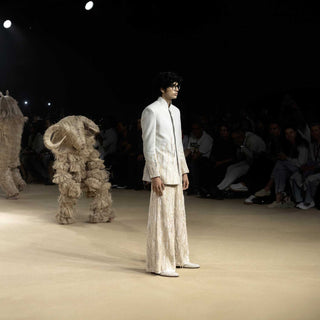 Runway model in bandhgala jacket and textured wide-leg pants – modern artisanal menswear - Designer bandhgala for men, Luxury Indian menswear, Artisanal menswear