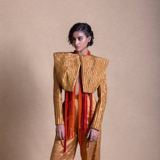 Close-up of a model in a Structured designer jacket paired with flared pants, angular shoulder panels - high fashion ensemble, powershoulder jacket, metallic.