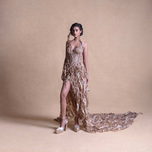 Full-length studio shot of model in nude corset gown with shredded fringe train - couture runway dress, eveningwear fashion