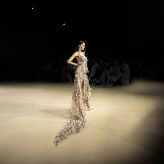 Model in corset gown with long feathered trail on runway - futuristic couture ensemble. redcarpet cocktail gown,  feather trail dress, runway fashion