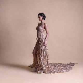 Side profile of model in Structured 
 gown with high slit and textured trail - futuristic couture ensemble. redcarpet cocktail gown
