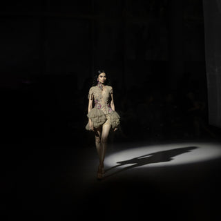 Model walking on a dark runway with spotlight