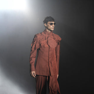 Men’s rust textured bandhgala jacket with sculpted shoulder detailing and matching trousers on runway