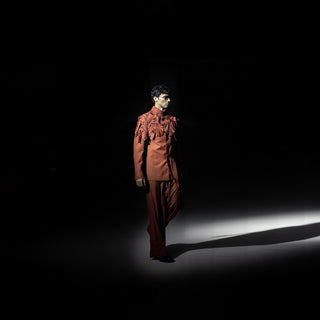Mannequin wearing a brown outfit against a black background