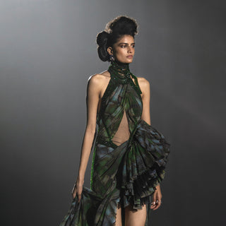 Model wearing a green and black dress with a textured texture against a gray background