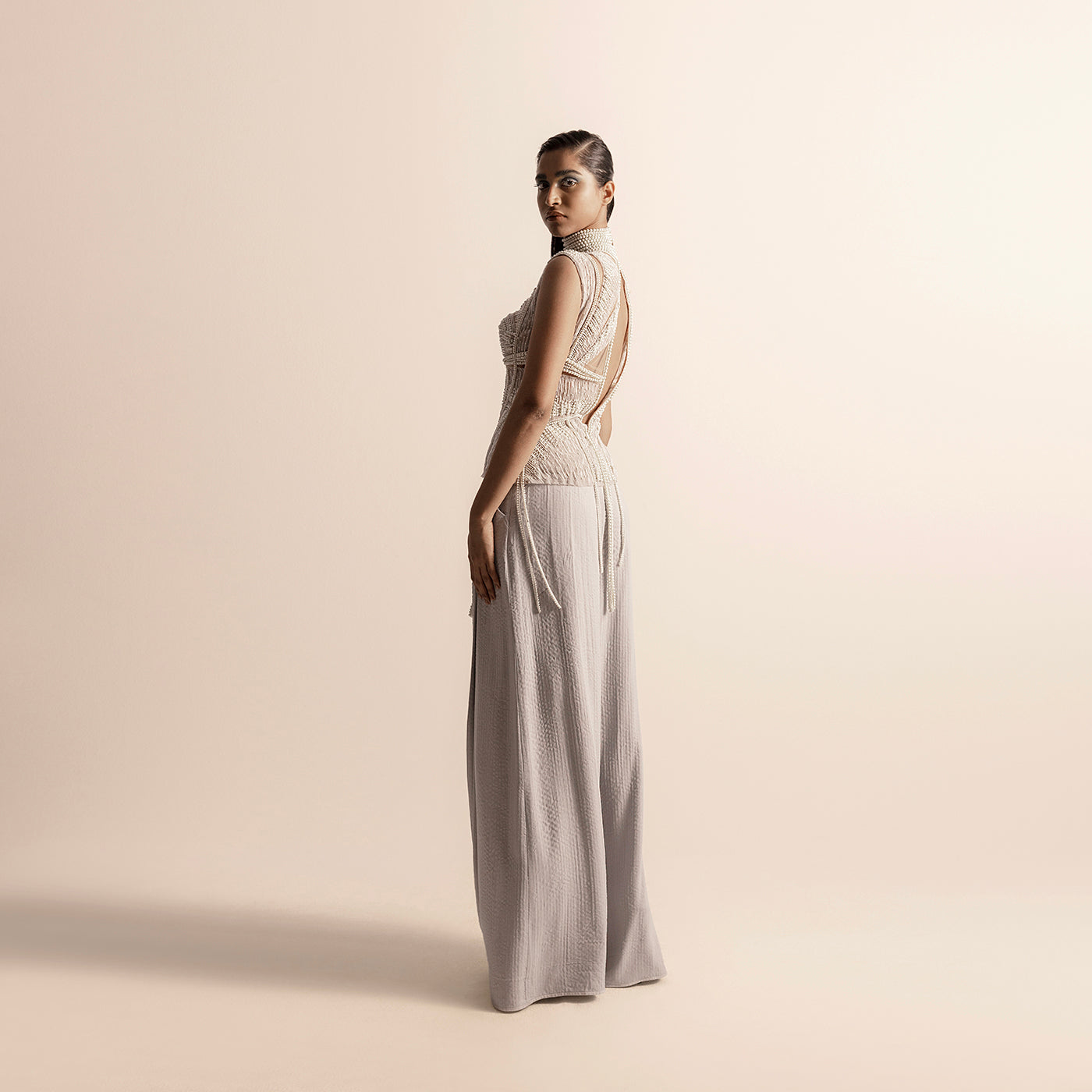 Side-back view of Fluted pearl embellished high-neck corset top with open back and wide-leg quilted trousers – high neck couture, quilted trousers, designer coordinated set