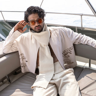 Ivory cropped jacket and pleated trousers with layered scarf – modern resortwear look for stylish and breathable summer dressing