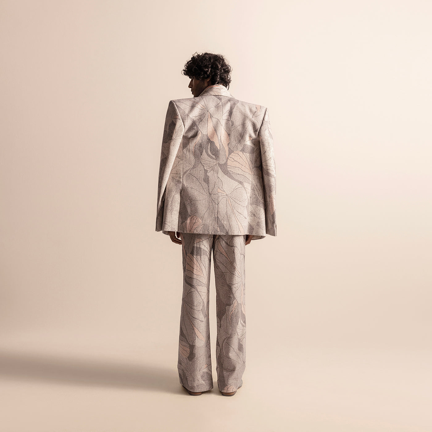 Back view of Nadru printed men's suit with wide-leg trousers and sharp-shouldered blazer, statement blazer, artistic tailoring