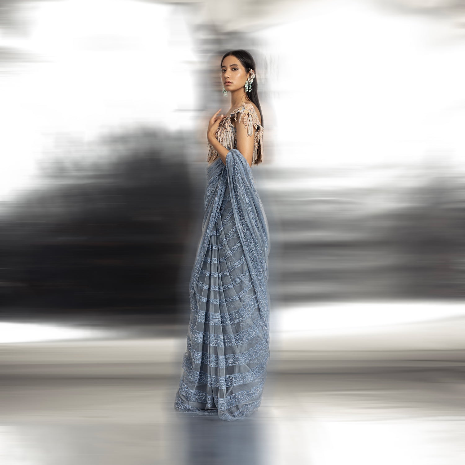 side view of Women's powder blue net saree with resham embroidery and fringe-detailed blouse – refined designer drape for festive occasions