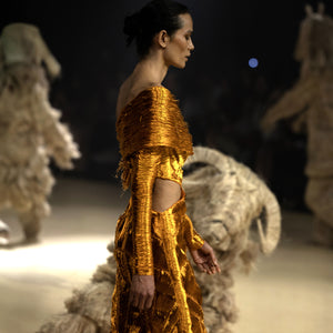 Model in a gold textured gown with side cut-out walking the runway - avant-garde designer gown, metallic cocktail dress, red carpet look