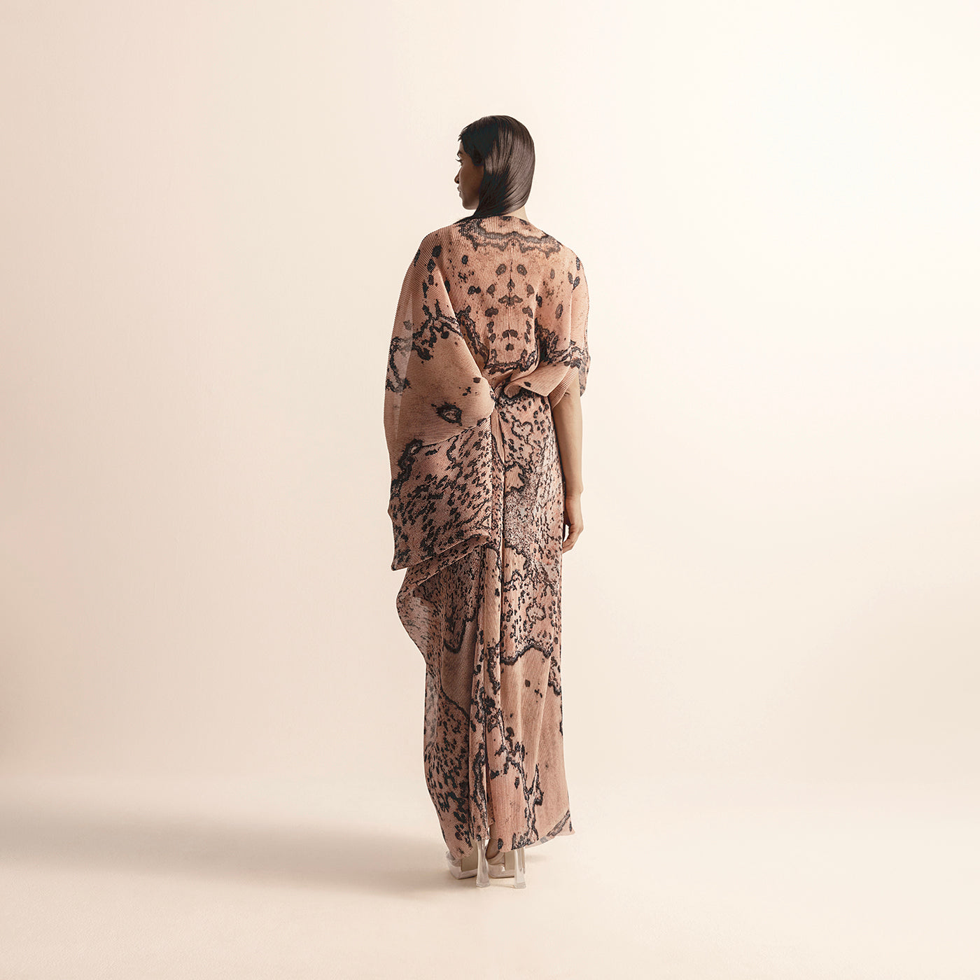 back view of Women's blush reef printed chiffon gown with sculptural back drape and heat textured detailing – coral couture elegance