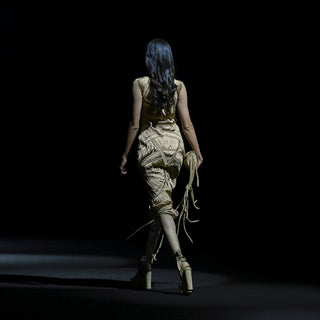 Women's back view of sculpted yarn-textured midi dress with handcrafted fringe – runway couture silhouette