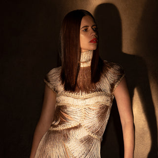 Close-up of women's gold fringe gown with high neck and sculpted yarn texture – luxe handcrafted couture fashion