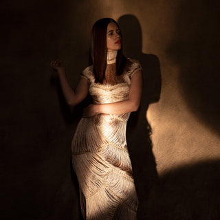profile shot Women's sculpted fringe couture gown in gold yarn with high neck and cap sleeves – artisanal evening fashion