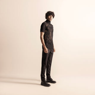 Men's black short-sleeve top with intricate yarn embroidery – avant-garde festivewear with structured pants