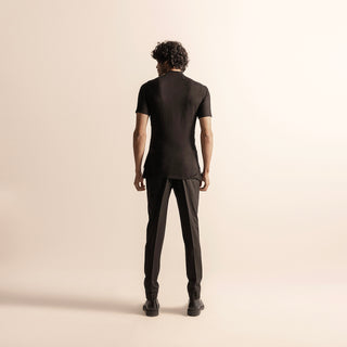 Men's black short-sleeve fitted top with clean back panel – minimalist couture pairing with tailored trousers