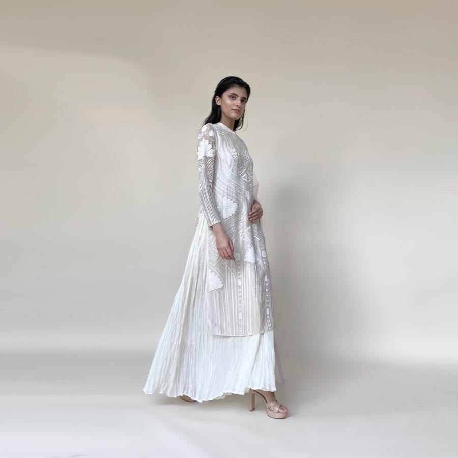 Organza silk kurta with fine Gresham and velvet applique embroidery embellished with pearl and katdana. There is a separate crinkled voile inner that gives the style a layered look. Elegance and delicate details are the main focus of the look. Abhishek Sharma, abhishekstudio