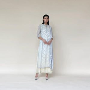 Chiffon Kalidas kurta with fine Resham shadow work and sequin embroidery. The kurta set has layered look and comes with a draped shaped stole, fitted pants and separate flared lining. The look is perfect for a refreshing and relaxed day. The look is perfect when you want to carry the grace and elegance with understated style. 