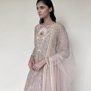 Organza silk kurta with fine Gresham and velvet applique embroidery embellished with pearl and katdana. There is a separate crinkled voile inner that gives the style a layered look. Elegance and delicate details are the main focus of the look. There is an interesting play of geometrical design with a hint of floral elements. Abhishekstudio, Abhishek Sharma