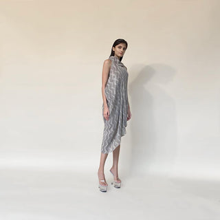 Chevron batik print pleat textured fluid draped georgette dress. It has draped ruffles around boat neck . It has a very fluid and elegant feel inspite of being an anti fit silhouette. The sleeveless draped cowl dress has very strong and dramatic vibe to it. abhishek sharma, abhishekstudio
