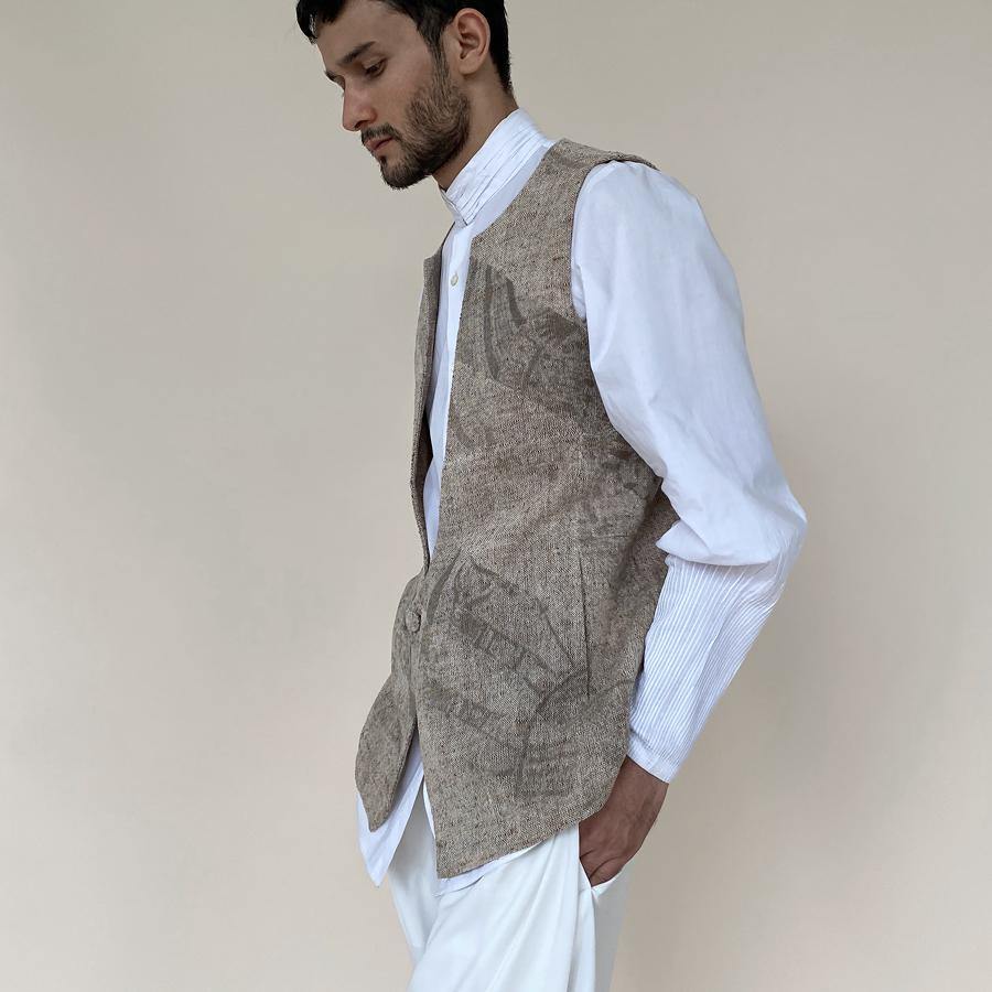 Handloom khadi bundi with single botton closure and shaped back. Cotton khadi shot texture bundi is ornamented with abstract distress print.  abhishek sharma, abhishekstudio