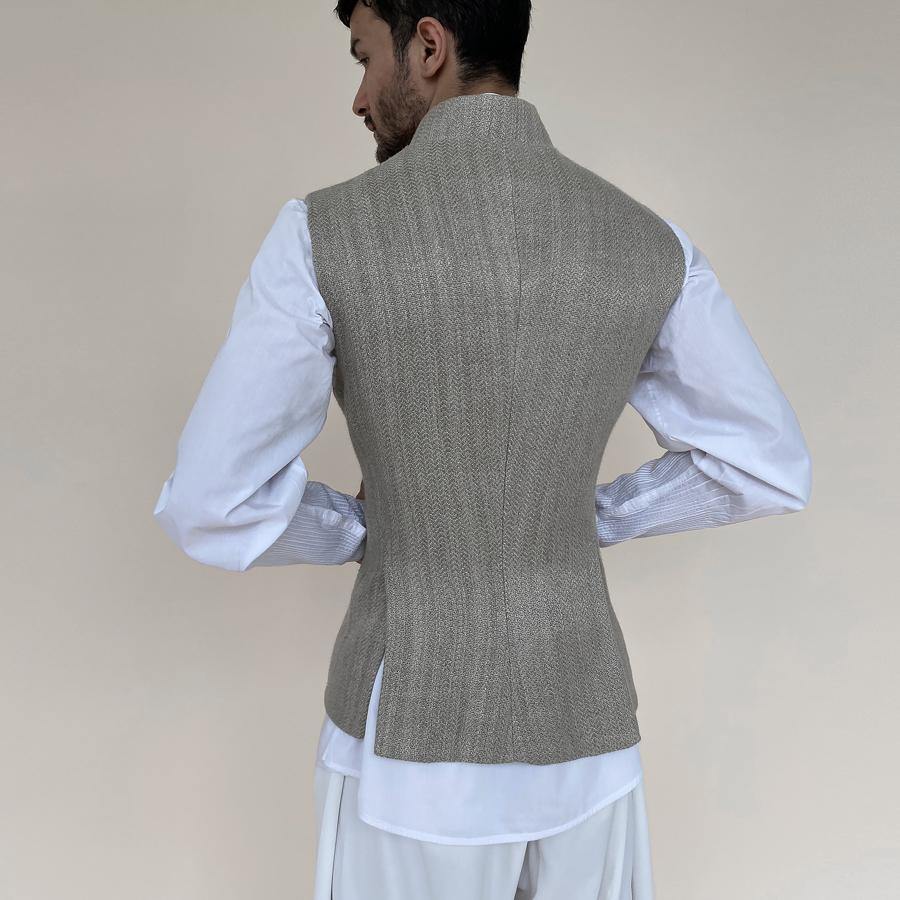 Shaped mandarin collar bundi with single button closure and concealed zipper. Heavy weight woven texture  linen bundi features double vents and shaped back for that extra ease while sitting and or on the go.  abhisheksharma , abhishekstudio