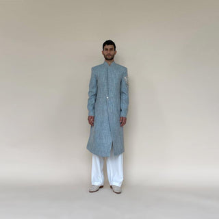 Shaped mandarin collar sherwani with single button front overlap closure. Heavy weight cotton khadi sherwani features high slits and slightly layered panels for that extra ease while sitting and or on the go. Sherwani is embellished with sequin and pearl lotus appliqué on the sleeve.  abhisheksharma , abhishekstudio