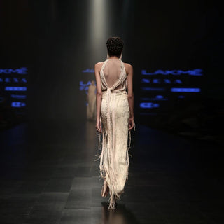 back view of Women's backless ivory co-ord with yarn drape halter detail and textured pencil skirt for high-fashion runway