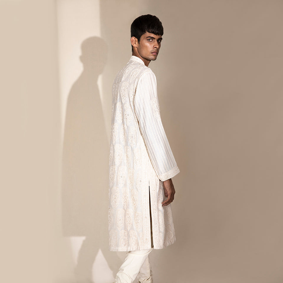 medium side shot of Men's ivory embroidered Chikankari kurta with vertical striped sleeves and side slits – classic festive ensemble