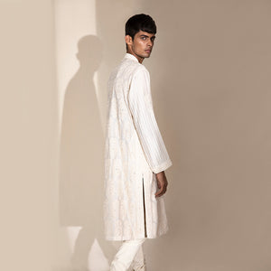 medium side shot of Men's ivory embroidered Chikankari kurta with vertical striped sleeves and side slits – classic festive ensemble