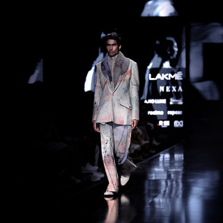 Men's runway look in abstract crystal-print suit with flared trousers and scarf-draped shawl collar – high-fashion Lakmé couture ensemble