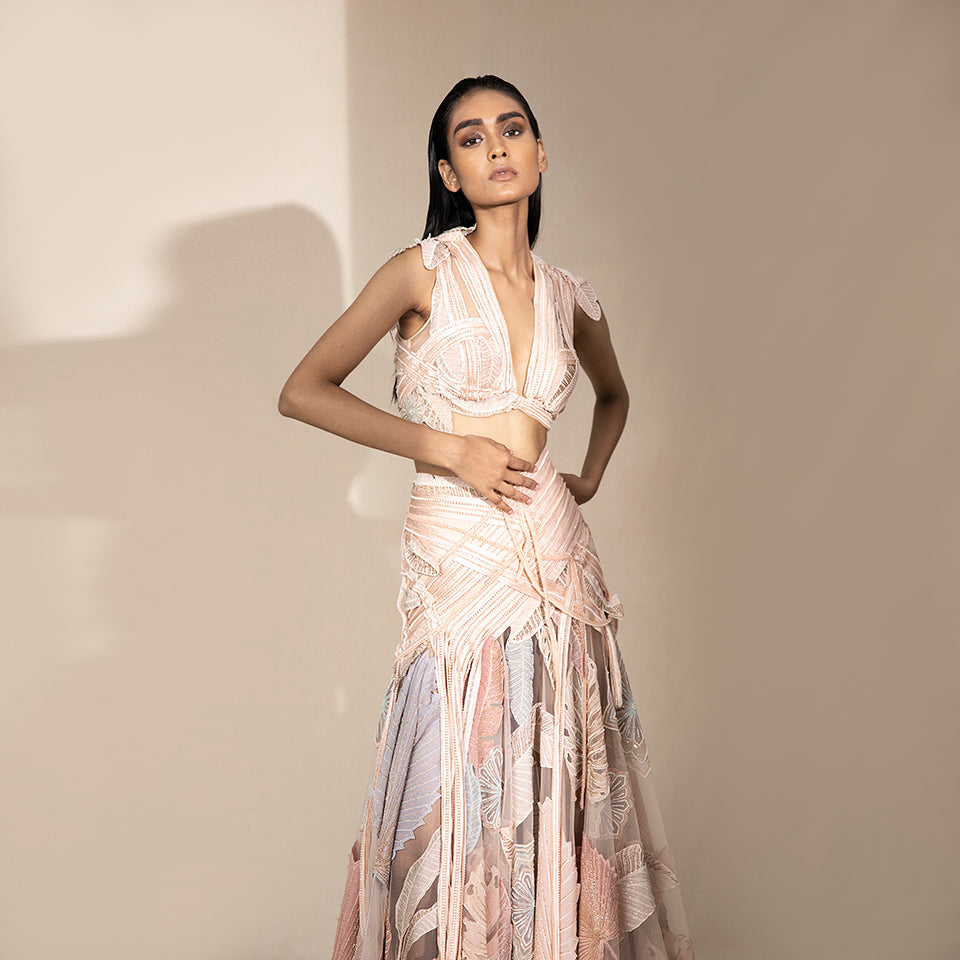 medium shot of Women's blush deep V-neck crop blouse with pastel embroidered skirt – luxury sangeet-ready designer co-ord set with leaf motifs